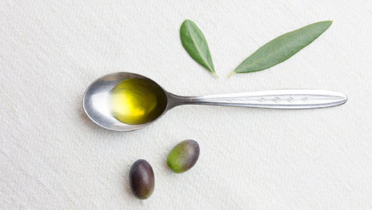 olives and spoon with olive oil