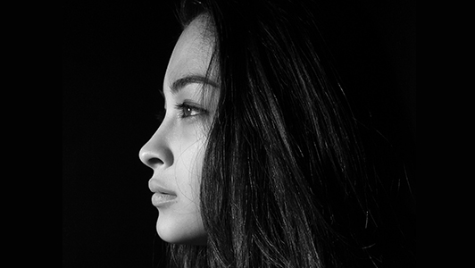 Black and gray profile photo of a girl with long hair.