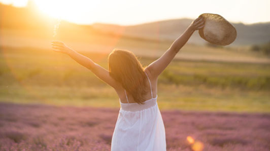 happy woman in field praising the beauty of life