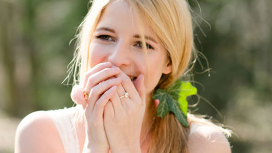 woman with leave in hair showing surprised self