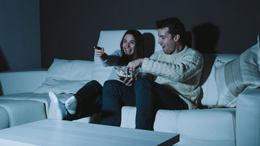 couple sitting on couch watching a comedy