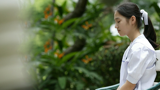 Girl sitting with her eyes closed.