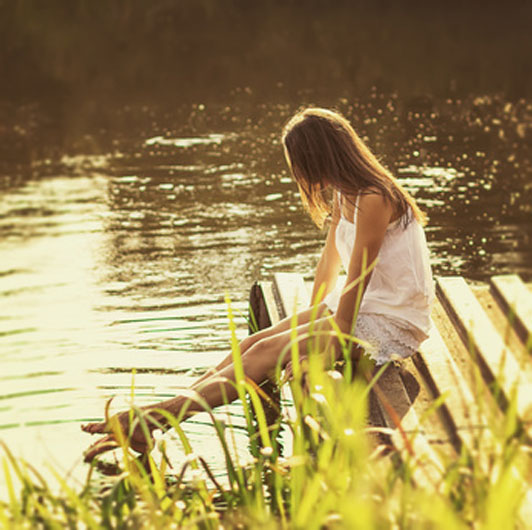 girl sitting by river