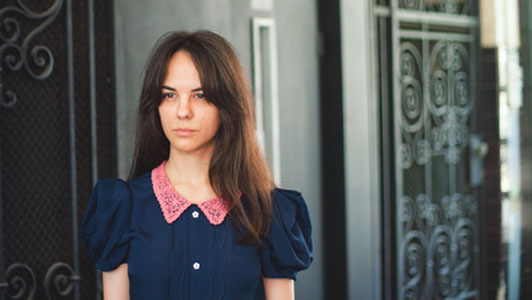 angry woman standing in hallway before open black door