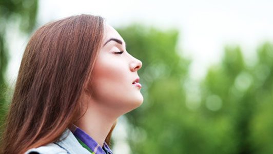 woman breathing fresh air outdoors