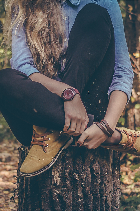 Girl sitting on a tree stump.