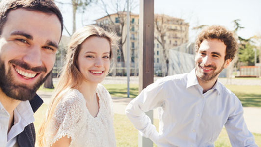 woman sitting between two men in park