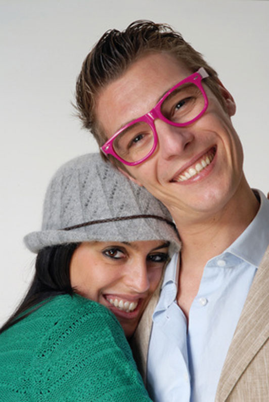 girl in grey beanie and guy in pink eyewear in embrace