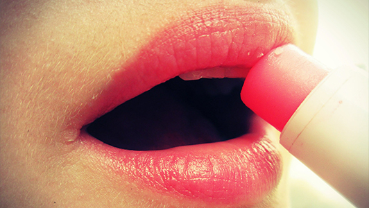 Girl putting on lipbalm.