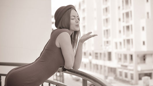 woman blowing kiss from balcony
