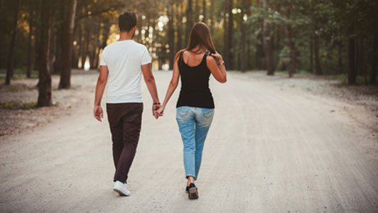 dating couple as seen holding hands while walking down the road