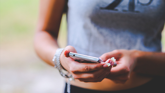 Girl with long nails holding a smartphone.