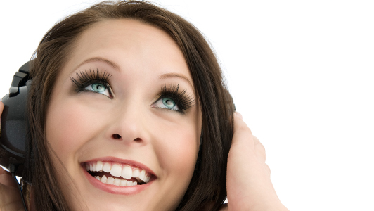 Brunette girl with long lashes wearing earphones.