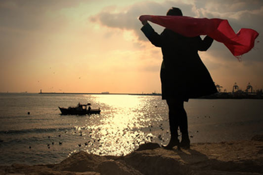 woman looking at sunset over open sea