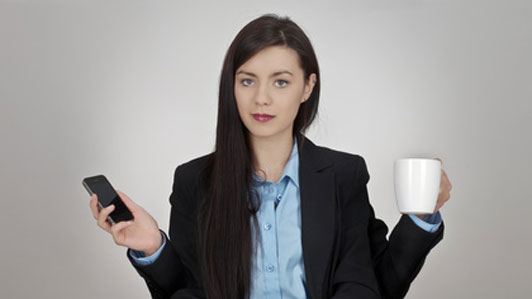 multitasking woman holding coffee cup