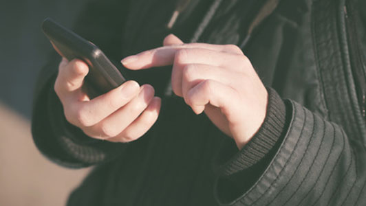 woman in black jacket send a text