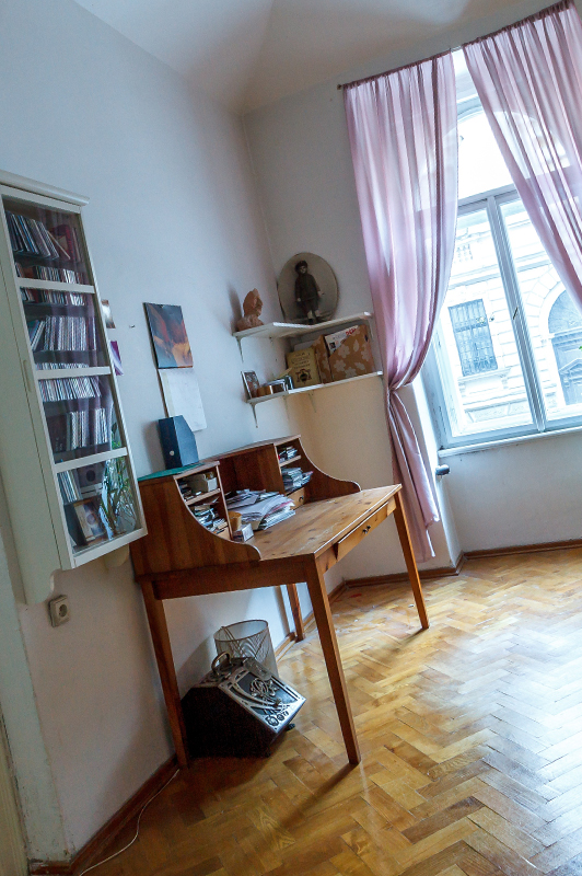 Shelves and a desk in a room with pink curtains.