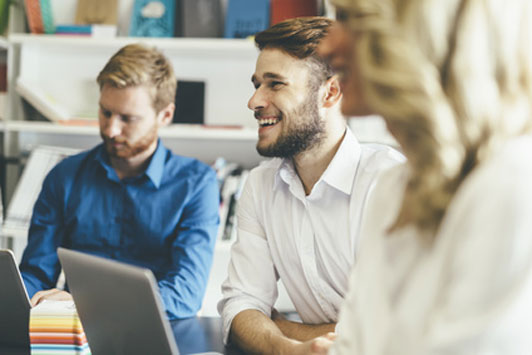 view of man smiling between coworkers