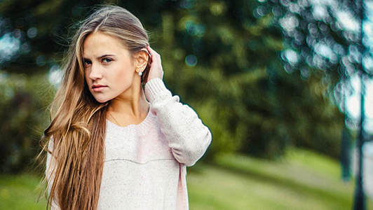 Girl moving her long hair behind her ear.