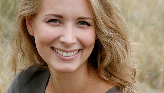 Natural looking woman with in green blouse smiling.