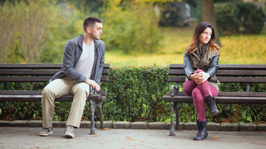 two people sitting in separate benches