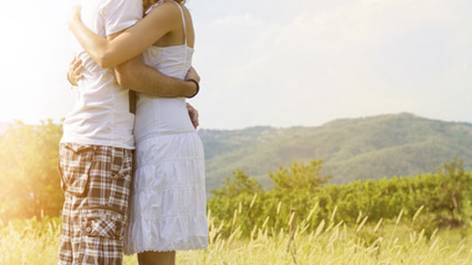 couple huggin in field