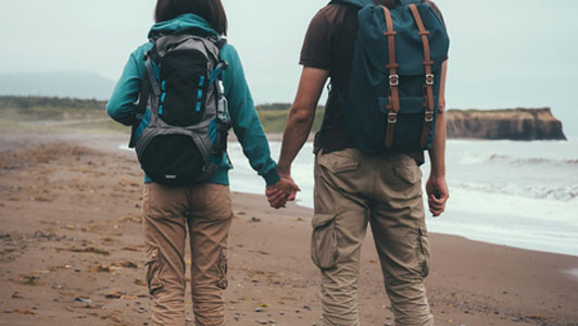 traveler couple holding hands at beach