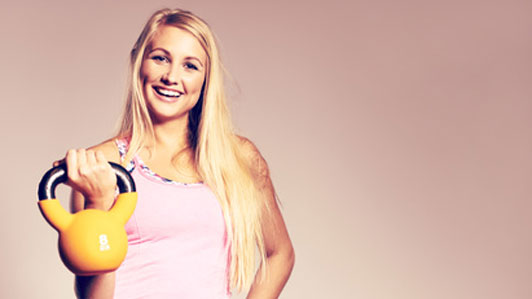 smiling woman holding kettlebell