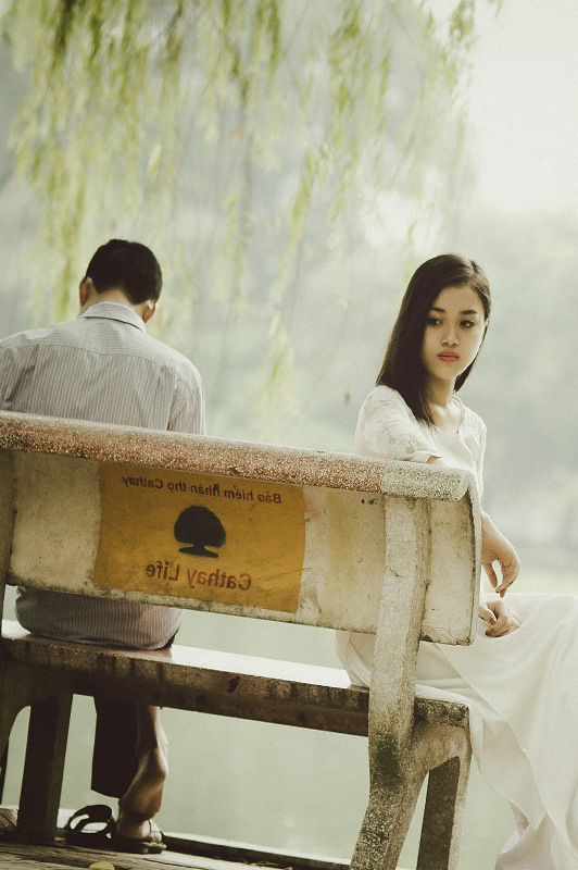 a couple sitting on a white bench