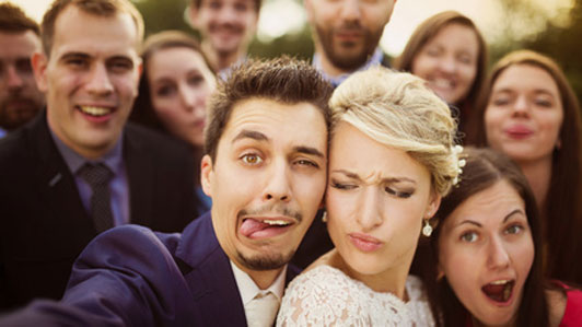 couple in wedding trying to take selfie