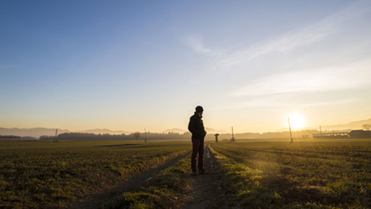 man standing alone on country road