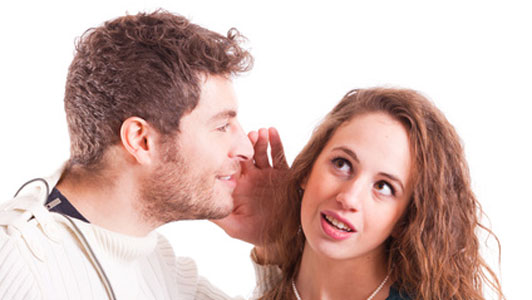 woman listening to secret from man through eye