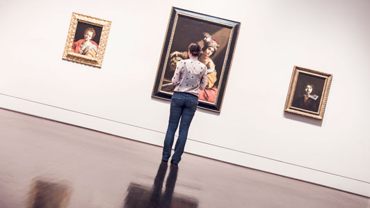 women looking at portraits