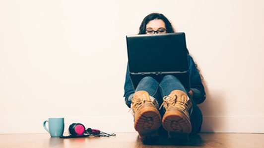 woman with laptop sitting on floor