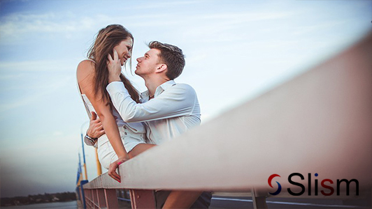 romantic couple sitting on a bridge