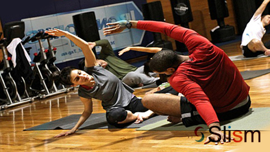 couple doing yoga in a gym