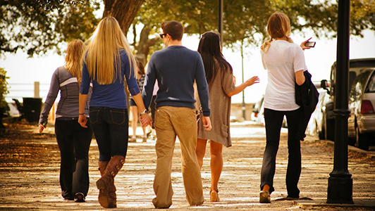 Couple holding hands while walking with a group of people