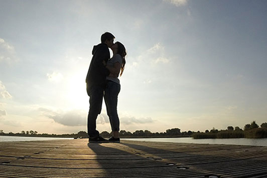 young couple kissing on road