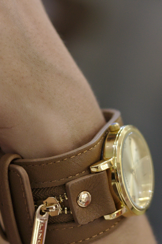 Close-up of a leather and gold watch.