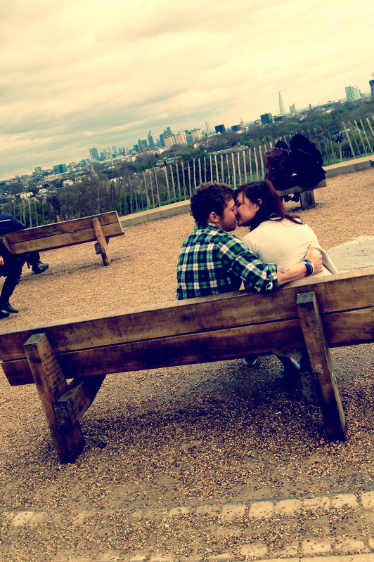 Couple sitting on a bench and kissing.