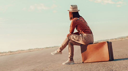 girl sitting on luggage