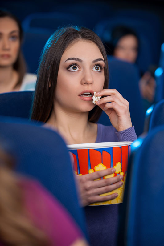 girl eating popcorn at movies