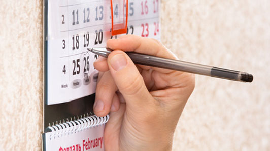 woman marking date on calendar