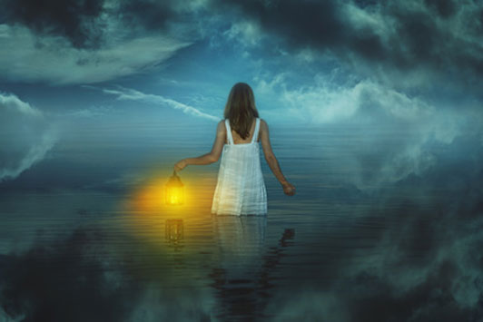 woman holding lantern in waters of strange dream land
