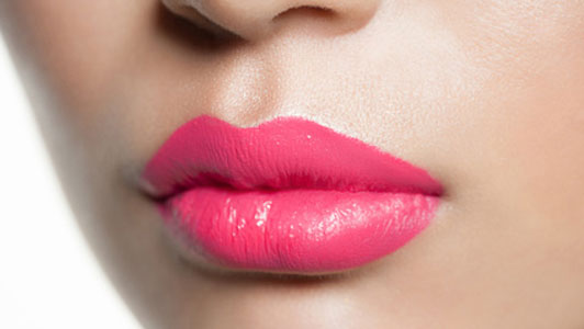 lips of woman covered with bright pink lipstick