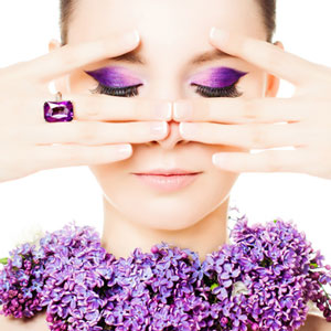 purple eye shadow woman wearing ring cropping eyes with fingers