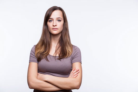 girl in purple shirt standing with arms crossed