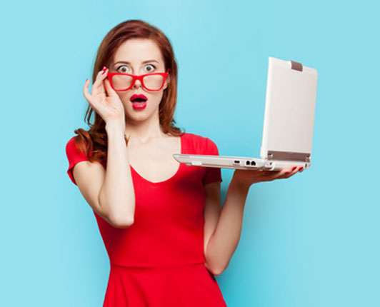 surprised girl in red shirt holding laptop computer with one hand