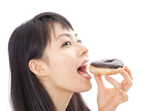 girl eating chocolate covered donut