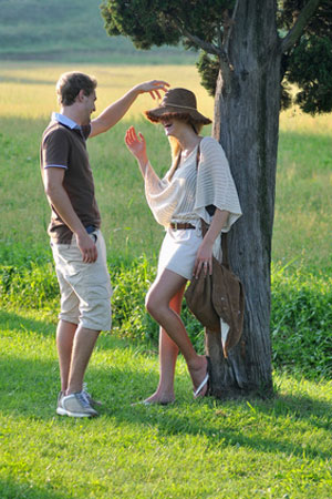 man jokingly covers eyes of woman with hat